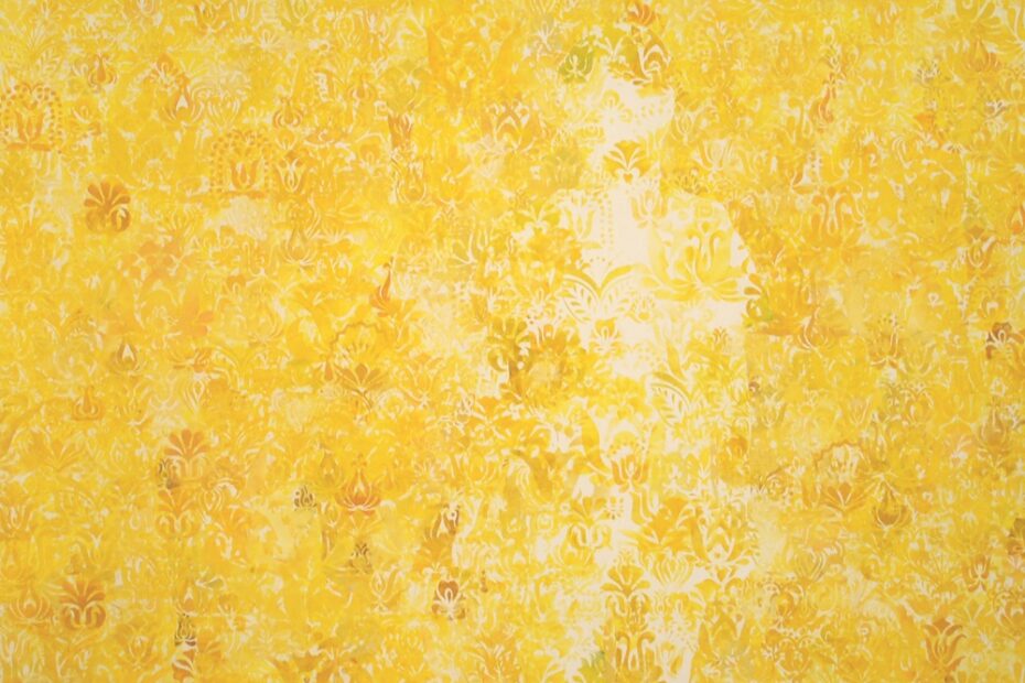 Imagem de um papel de parede amarelo com um vulto escondido por trás dos desenhos