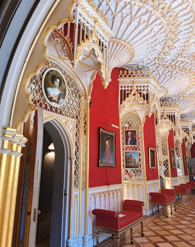 Salão de visitas com paredes vermelhas e decoração em dourado